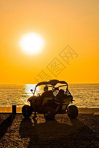 日落海边的四轮摩托车图片