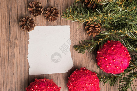 在旧橡木上用纸松锥树枝和圣诞节球设计的基督边框图片