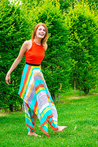 赤脚女孩穿着礼服在公园的草坪上图片