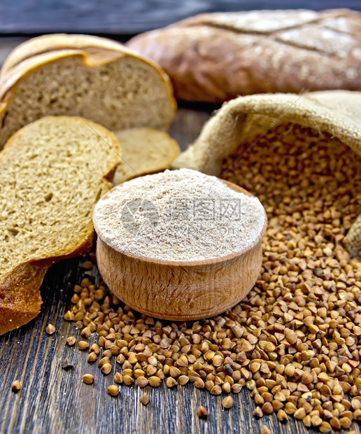 木碗中的面粉袋小麦木板背景上的面包片图片
