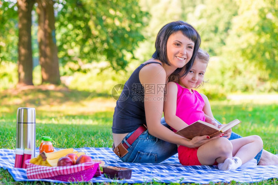 年轻的母亲与女儿在野外就餐图片