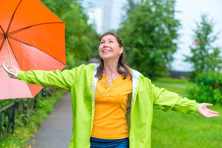 快乐的年轻女士享受公园的夏雨图片