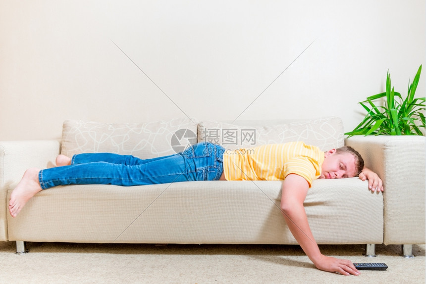 男人在客厅看电视后睡在沙发上图片