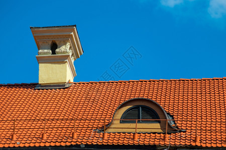 在阳光明媚的一天屋顶上盖着红色瓷砖图片