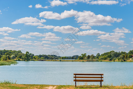 阳光明媚的一天湖边空的板凳图片