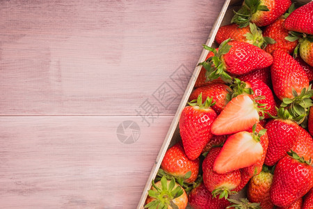 木制桌上篮子中的新鲜草莓带有复制空间的顶视图图片