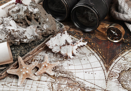 古背景上的海星贝壳矿物焦利特标罗盘旧望远镜绳子和纸卷图片