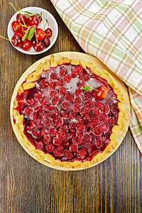 甜馅饼加樱桃和果冻餐巾纸樱桃盘放在木板底的图片