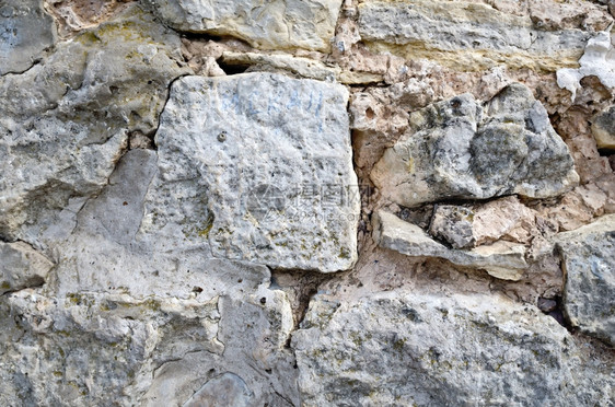 由各种大小的粗石头建造旧墙图片