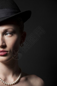 黑色背景的帽子美丽年轻模特的肖像图片