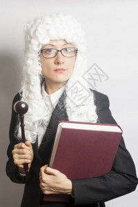 女法官佩戴假发和背挂着眼镜戴法官大锤和白背面书的女法官图片