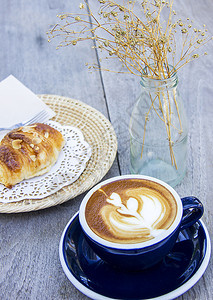 早餐咖啡和木桌上的杏仁角面包图片