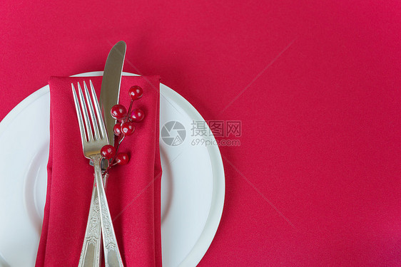 白瓷板上有刀和叉子红色纸巾薄和胡椒浆白瓷板位于一张上面有红色桌布的子上有文字空间图片