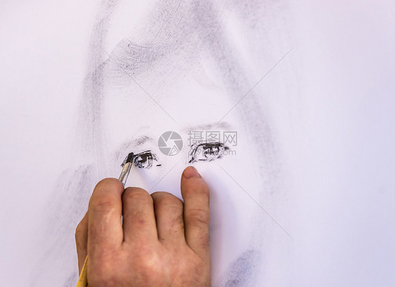 man手工绘画女孩和眼睛使用刷子与艺术家和亲手关闭图像而他画女孩和在肖像中绘制眼睛图片