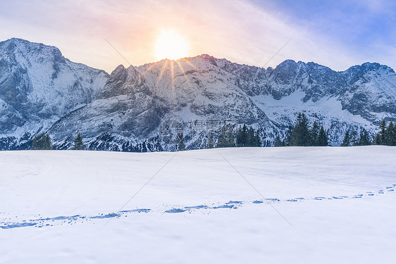 太阳照耀在被雪覆盖的山上图片