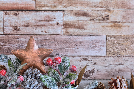 装饰圣诞星的特写镜头木质背景上有杉木树枝和雪花粉末的圆锥体图片