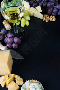 白葡萄酒各种类的奶酪胡桃和黑板石本底的葡萄图片
