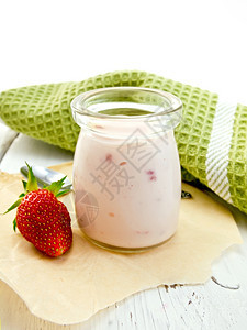木板上的玻璃罐里有草莓酸奶图片
