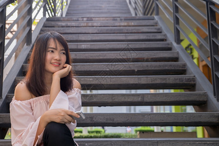 年轻微笑的女士户外肖像柔软的阳光色彩接近的肖像美丽微笑女孩夏天在城里的女人夏天户外肖像图片