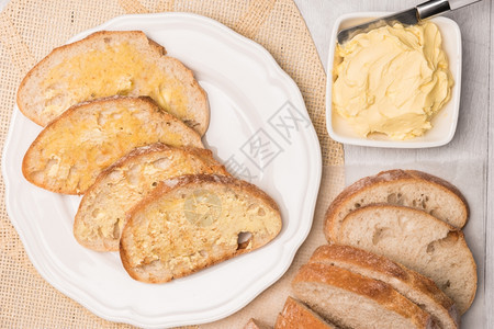木制背景上的新鲜面包和自制黄油带有复制空间的顶端视图图片