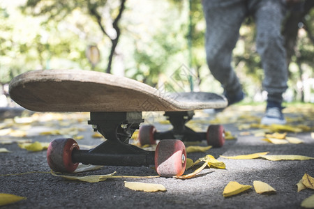 男孩在公园玩滑板秋叶图片