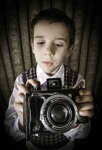 双手拿着老式相机的男孩图片