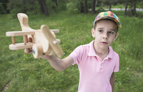 小孩在森林里玩木制飞机图片