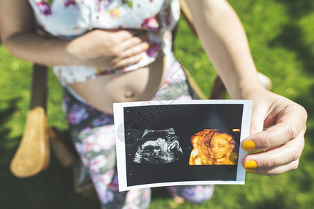 孕妇在花园展示子宫的照片图片