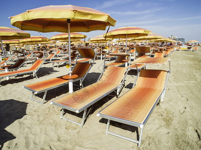 沙滩上的橙色太阳床和雨伞图片