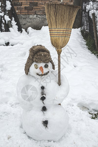 在院子里的雪人拿着扫帚图片