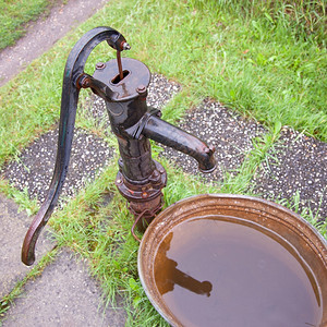 园艺和锌浴缸中的旧湿式铁水泵图片