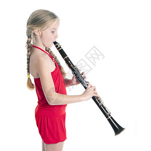 年轻女孩在白色背景下学习吹单簧管图片