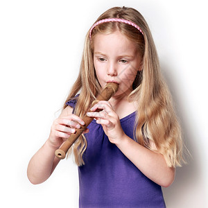 身着紫色衣服的小女孩在白色背景下练习吹木笛的照片图片