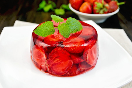 草莓果冻薄荷和浆盘子里的和草莓在黑色木板底的毛巾上图片