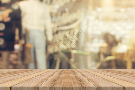 在咖啡店背景中模糊可见的棕色木质桌可模拟用于显示或设计关键视觉布局的假冒产品图片