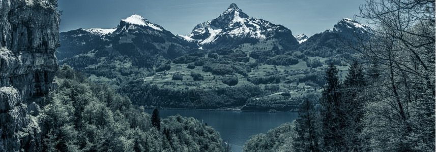 湖边的长江及其美丽周围雪山峰和巨大的悬崖加上深蓝色的颜图片