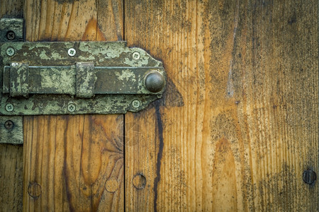 从一个德国马厩的木制门有生锈的金属门锁和老旧的木制板良好的框架右侧有复制空间供文字使用图片