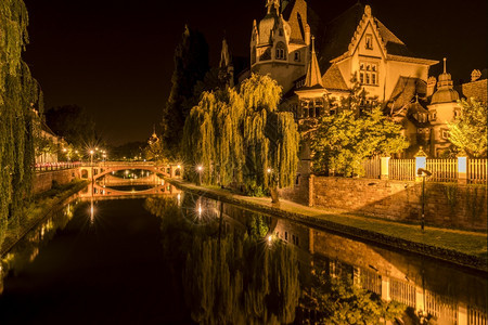 与中世纪的房子和两座石桥的夜拍摄影美丽的开明以及他们从法国斯特堡到河里的水反射图片