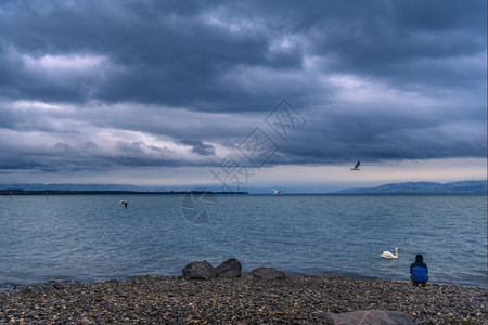 与波德森湖的风景从油炸沙芬镇德国在一个雨季而人坐在它的海岸上冥想图片