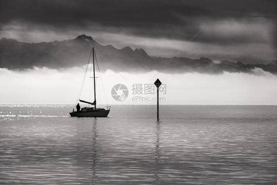 黑白的景色在港湾湖上乘船航行地平线上有山岳和晨雾图片