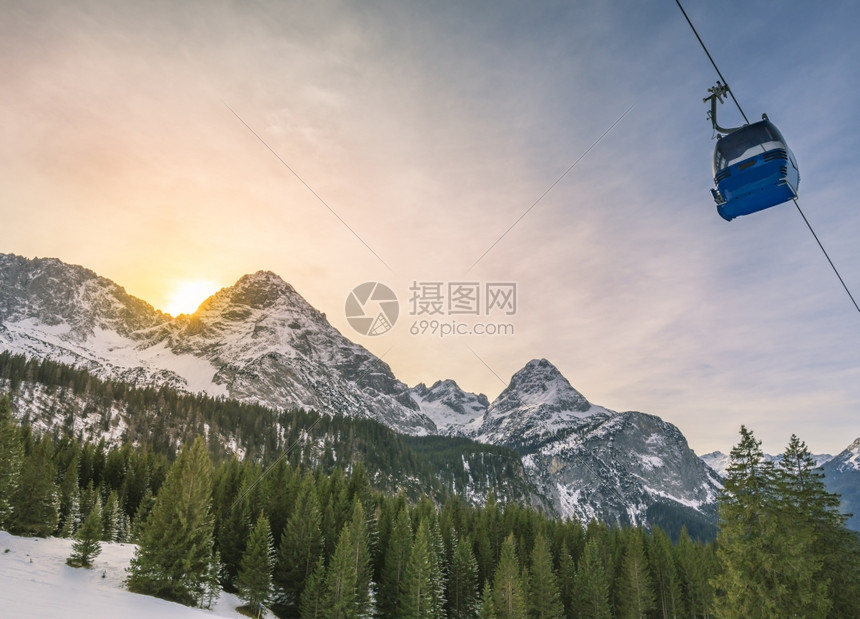 一辆经过高山和森林的电缆车图片