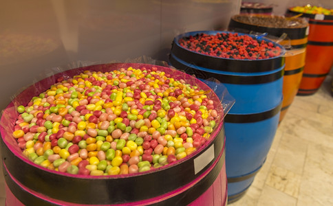 以多彩木制桶展示的美味食多种颜色和形状的糖果图片