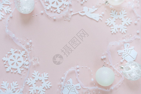 由白月装饰组成的圣诞节框架雪花球飞行天使和粉红色背景的礼品盒网站社交媒体企业主杂志博客艺术家等的平板固定结构图片