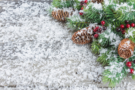 圣诞框架由木板背景上的绿色树枝松果和胡利组成上面有白雪片贺卡网站社交媒体杂志博客艺术家等平整的固定组成图片