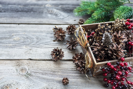 圣诞装饰全木箱的松果和红胡椒树枝以旧的未油漆木板为背景贺卡网站社交媒体商业主杂志博客艺术家等的圣诞组成图片