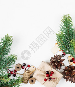 圣诞节框架由圆枝锥形红胡莓和礼品盒组成与白色背景带文字空间的黄麻绳绑在白色背景上贺卡网站社交媒体杂志博客艺术家等的平整固定版面组图片
