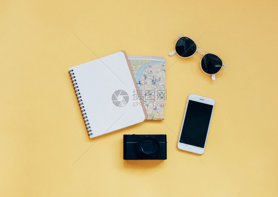 旅行项目概念黄色背景的空白笔记本照相机智能手和太阳镜顶视面风格最低图片