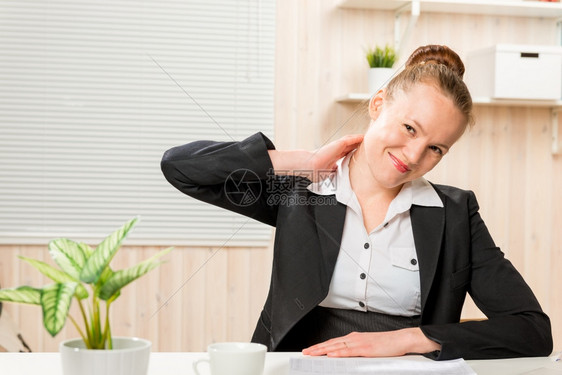穿着商业西装的女人摩擦他脖子这是痛苦的工作在电脑上图片