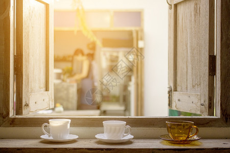 露天外观的木窗玻璃上的咖啡杯图片