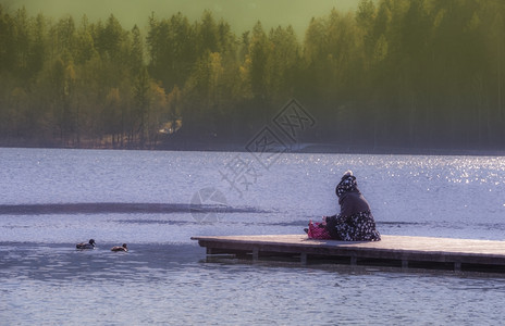 坐在12月早晨的木码头上湖边流血在斯洛维尼亚图片